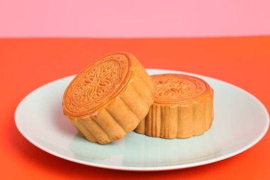 Geleneksel Çin tatlı ay çöreği ya da pembe ve turuncu arka planda Çin pastası. Çin Geleneksel Sonbahar Festivali, Ay Festivali.