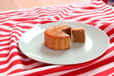 Geleneksel Çin tatlı ay çöreği ya da pembe arka planda izole edilmiş kırmızı çizgili masa örtüsü üzerine Çin pastası. Çin Geleneksel Sonbahar Festivali, Ay Festivali.