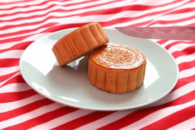 Geleneksel Çin tatlı ay çöreği ya da pembe arka planda izole edilmiş kırmızı çizgili masa örtüsü üzerinde Çin pastası kesmeye hazır olun. Çin Geleneksel Sonbahar Festivali, Ay Festivali.