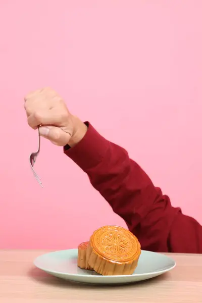 Geleneksel Çin tatlı ay çöreği yemek için çatal ya da pembe arka planda Çin pastası. Çin Geleneksel Sonbahar Festivali, Ay Festivali.