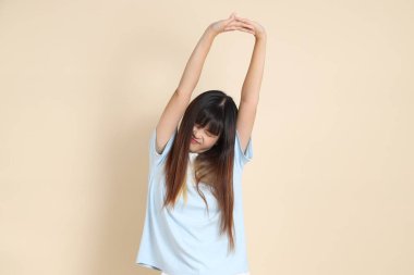 Açık mavi polo tişört giyen genç Asyalı kadın ve beyaz şort, bitkin, tembel ve ciddi olmayan.