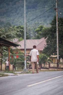 Boru, Larantuka, Endonezya-5 Haziran 2024: Lewotobi 2024 Yanardağı 'nın patlaması nedeniyle volkanik küllerle dolu Boru-Hokeng-Larantuka otobanından bir adam geçiyor.