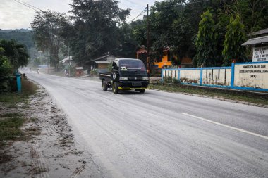 Boru, Larantuka, Endonezya-5 Haziran 2024: Lewotobi yanardağının patlaması sonucu volkanik küllerle dolu Boru-Hokeng-Larantuka yolundan geçen arabalar