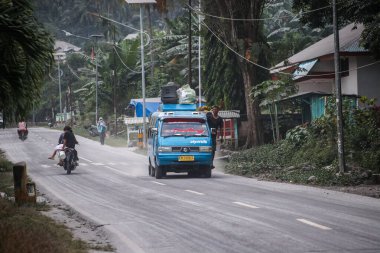 Boru, Larantuka, Endonezya-5 Haziran 2024: Motosiklet sürücüleri Lewotobi 2024 Yanardağı 'nın patlaması nedeniyle volkanik küllerle dolu Boru-Hokeng-Larantuka otobanından geçtiler.