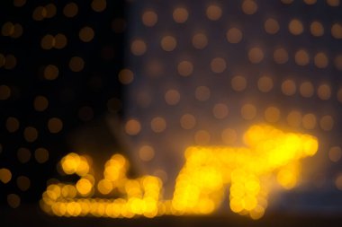 Kendinizi bu şenlikli bokeh 'in büyüleyici atmosferine daldırın, 75 mm' lik bir objektifle tam kare bir kameraya yakalandınız. Görüntü, parıldayan ışıklar ve altın bir Ch ile süslenmiş bir kızağı çeken bir ren geyiğinin bulanık ama tanınabilir bir siluetini gösteriyor.