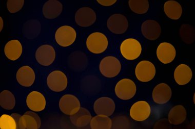 Tasarımlarınızı F1.8 açıklığında 75 mm 'lik mercekle yakalanan bu bokeh' in şenlikli parıltısına daldırın. Görüntü, koyu bir arkaplana karşı büyük, zarif altın tonlu bokeh ovalları içeriyor. Kutlamalar ya da portreler için ideal bir arka plan.