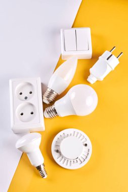 Loş düğmeli elektrik ışığı ayarlandı, kontrol edilebilir ışıklandırma. Enerji tasarrufu kavramı, beyaz sarı arkaplanda izole edilmiş elektrik gücünü değiştirmek için tasarlanmış aygıt