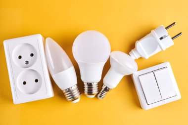 Loş düğmeli elektrik ışığı ayarlandı, kontrol edilebilir ışıklandırma. Enerji tasarrufu kavramı, sarı arkaplanda izole edilmiş elektrik gücünü değiştirmek için tasarlanmış aygıt