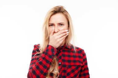 İğrenç kokudan kaçınmak için burnunu tutan genç sarışın kadın parmaklarıyla burnunu ve ağzını sıkıyor ve beyaz arka planda nefesini tutuyor.