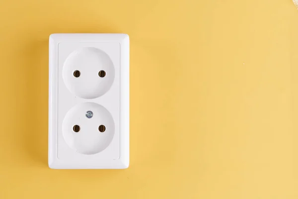 stock image White double socket isolated on yellow background. Electric lighting concept