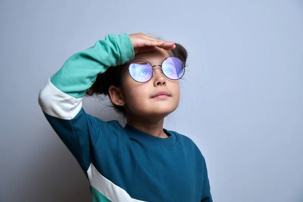 Mała Kaukaska Dziewczyna Okularach Patrzy Przyszłość Patrząc Daleka Ręką Nad — Zdjęcie stockowe