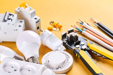 Elektriksel aletler, kontrol edilebilir ışıklandırma ile sarı arkaplanda izole edilmiş loş anahtar ile ayarlandı. Enerji konsepti, inşa ve yenileme tasarruf ediliyor