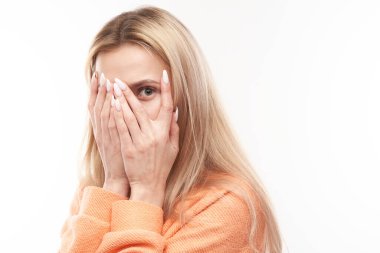 Genç sarışın kadın parmaklarından röntgenliyor, avuçlarını beyaz arka planda izole edilmiş avuçlarıyla gözlerini kapatıyor. Fobi Konsepti