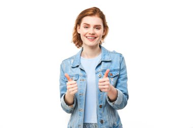 Genç kızıl saçlı kadın elini kaldırıyor ve beyaz arka planda izole kameraya gülümsüyor.