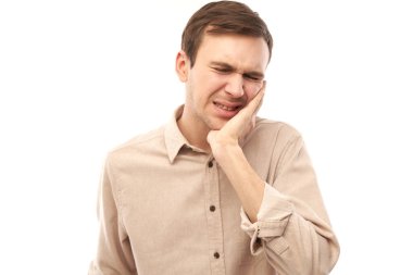 Yüzünde acı çeken esmer adam elleriyle yanak tutuyor, beyaz arka planda avuç içi izole edilmiş ağıza dokunuyor. Diş ağrısı, diş ağrısı konsepti