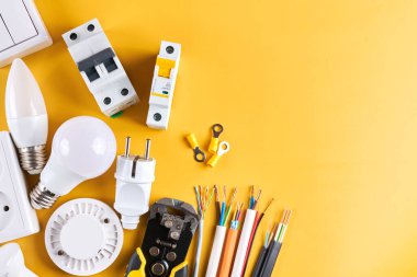 Elektriksel aletler, kontrol edilebilir ışıklandırma ile sarı arkaplanda izole edilmiş loş anahtar ile ayarlandı. Enerji konsepti, inşa ve yenileme tasarruf ediliyor