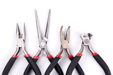 Beyaz arka planda farklı tipte pense ve yan kesiciler var. Tamir, inşaat ve bakım için el aletleri