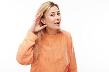 Genç sarışın kadın gülümsüyor ve el ele tutuşuyor, dikkatlice dinliyor, beyaz arka planda dikkatle izole edilmiş.