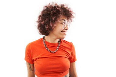 Beyaz stüdyo arka planında izole edilmiş, bukleli, dövmeli, zincirli, gülen ve gülümseyen havalı mutlu Kazak kız portresi.