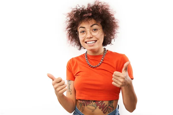 哈萨克黑发女孩 有纹身 手举着大拇指 对着被白色背景隔离的相机微笑 — 图库照片