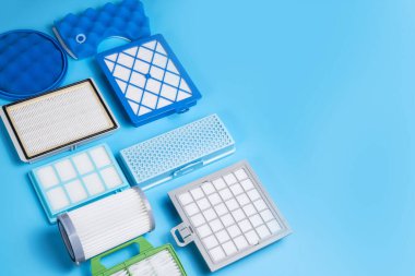 Mavi arkaplanda izole edilmiş elektrik süpürgesi için yeni temiz toz hava filtreleri