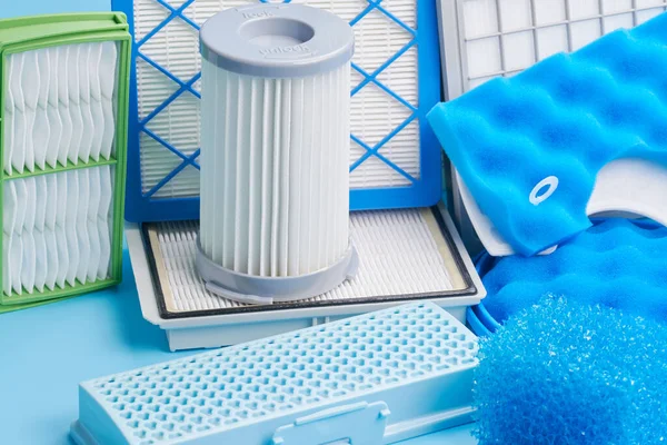 New clean dust air filters for vacuum cleaner isolated on blue background