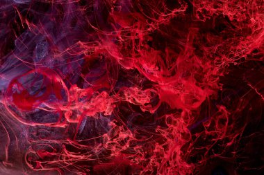 Red abstract ocean background. Splashes and waves of paint under water, clouds of smoke in motion.
