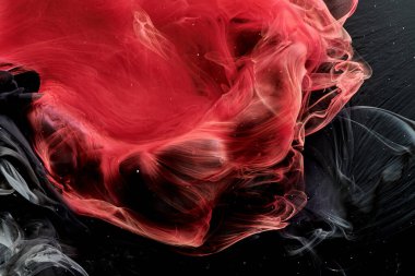 Red black abstract ocean background. Splashes and waves of paint under water, clouds of smoke in motion