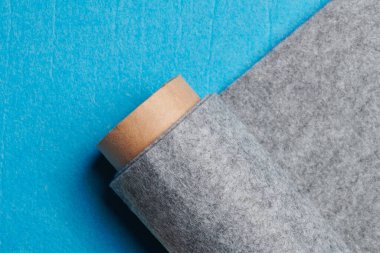 Soft felt textile material gray color, colorful texture fabric roll closeup