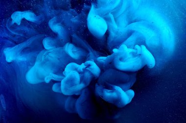 Blue abstract ocean background. Splashes and waves of paint under water, clouds of smoke in motion.