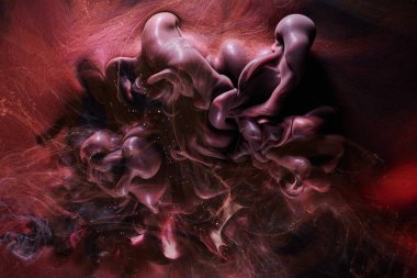 Red black abstract ocean background. Splashes and waves of paint under water, clouds of smoke in motion