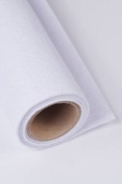 Soft felt textile material white color, colorful texture fabric roll closeup