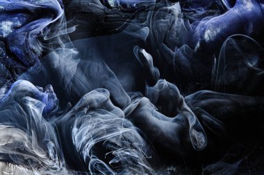 Koyu mavi soyut okyanus arka planı. Sıçramalar, damlalar ve dalgalar suyun altında parlayan boya bulutları hareket halindeki duman bulutları.