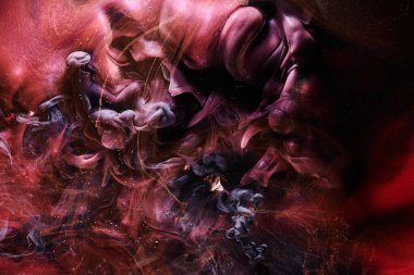Red black abstract ocean background. Splashes and waves of paint under water, clouds of smoke in motion