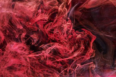 Red black abstract ocean background. Splashes and waves of paint under water, clouds of smoke in motion