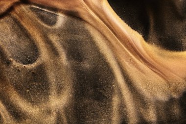 Black gold abstract ocean background. Splashes and waves of sparkling paint under water, clouds of interstellar smoke in motion