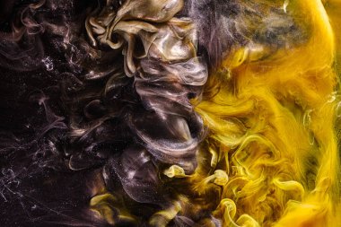 Black yellow abstract ocean background. Splashes and waves of paint under water, clouds of interstellar smoke in motion