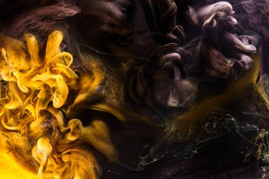 Black yellow abstract ocean background. Splashes and waves of paint under water, clouds of interstellar smoke in motion
