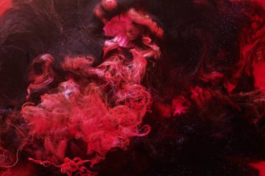 Red black abstract ocean background. Splashes and waves of paint under water, clouds of smoke in motion