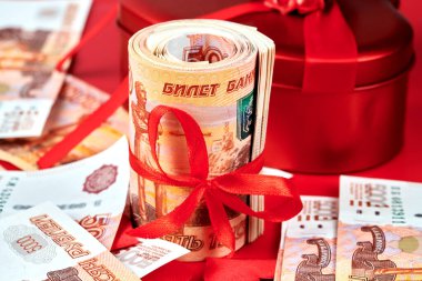 Kırmızı arka planda Rus rublesi, içinde kırmızı kurdele olan beş bin banknot, para hediye konsepti.