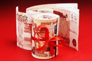 Rus Rublesi, beş bin banknot, kırmızı arka planda kırmızı kurdeleli bir tomar para, hediye konsepti.