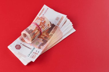 Rus Rublesi, beş bin banknot, kırmızı arka planda kırmızı kurdeleli bir tomar para, hediye konsepti.