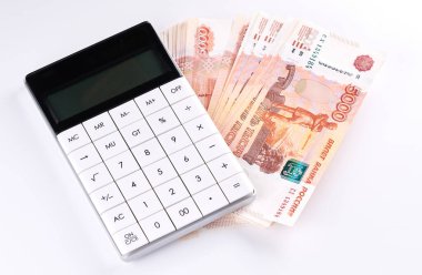 Rus Rublesi 5 bin banknot, hesap makinesi ve beyaz arka planda yığınla para.