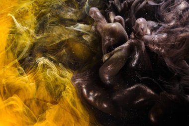 Black yellow abstract ocean background. Splashes and waves of paint under water, clouds of interstellar smoke in motion
