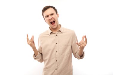 Beyaz arka planda izole edilmiş parmaklarıyla rock 'n roll hareketi yapan beyaz bir adamın portresi.