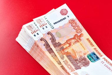 Rus rublesi. Beş bininci banknot. Kırmızı arka planda yığınla para.