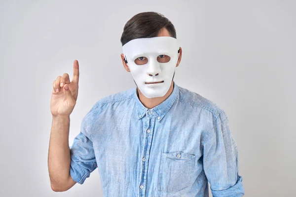 謎の男で白いマスクで彼の顔隔離された上のスタジオの背景 — ストック写真