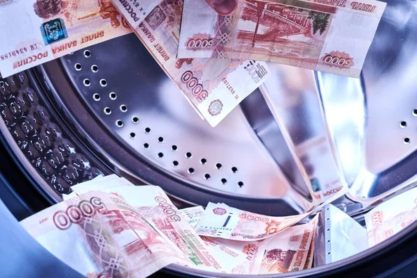 Russian banknotes in the washing machine. Money laundering, financial fraud concept