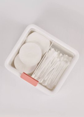 Beyaz arka planda izole edilmiş pamuk çubukları ve pedlerle dolu kozmetik ürünleri için beyaz yeni plastik düzenleyici