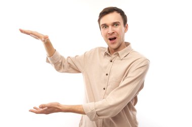 Beyaz tenli, esmer, beyaz erkek portresi. Boyutunu elleri ile gösteriyor. Ya da beyaz stüdyo arka planında izole edilmiş bir şey tutuyor.